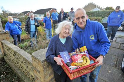 Aldershot Lions secretary Ian Hambleton presents a christmas hamper to the delighted Norra Richmond.