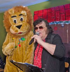 Aldershot Lions Lemmie the Lion helps Elvis sing along to the crowds at the Gateway Christmas Party